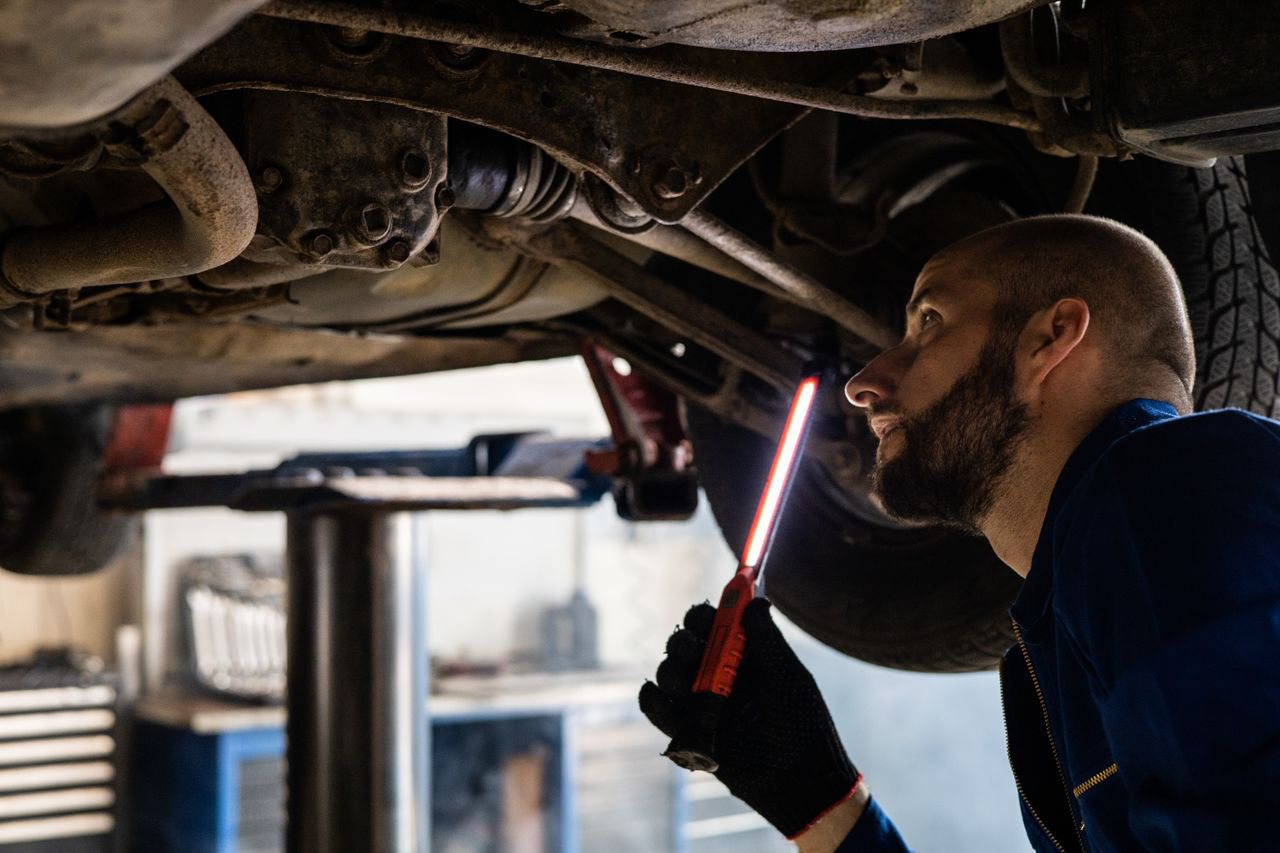 Car mechanic performing inspection on second-hand car