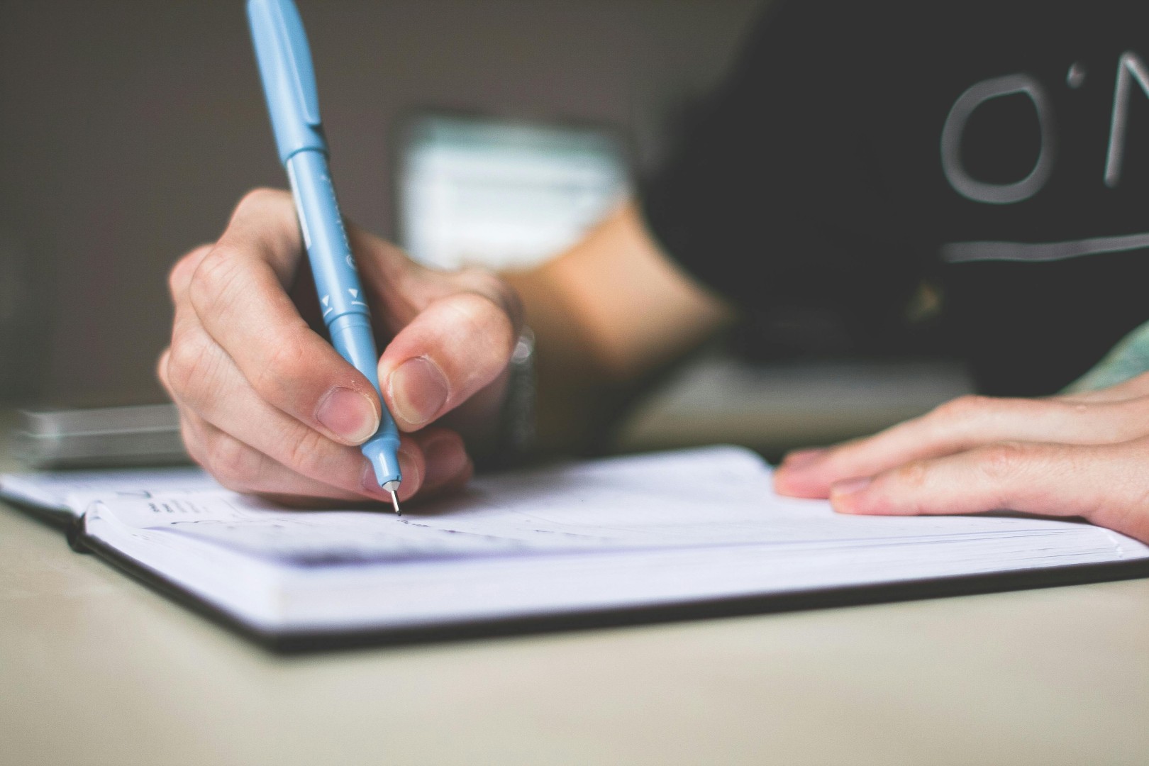 Close up of a hand writing with a pen